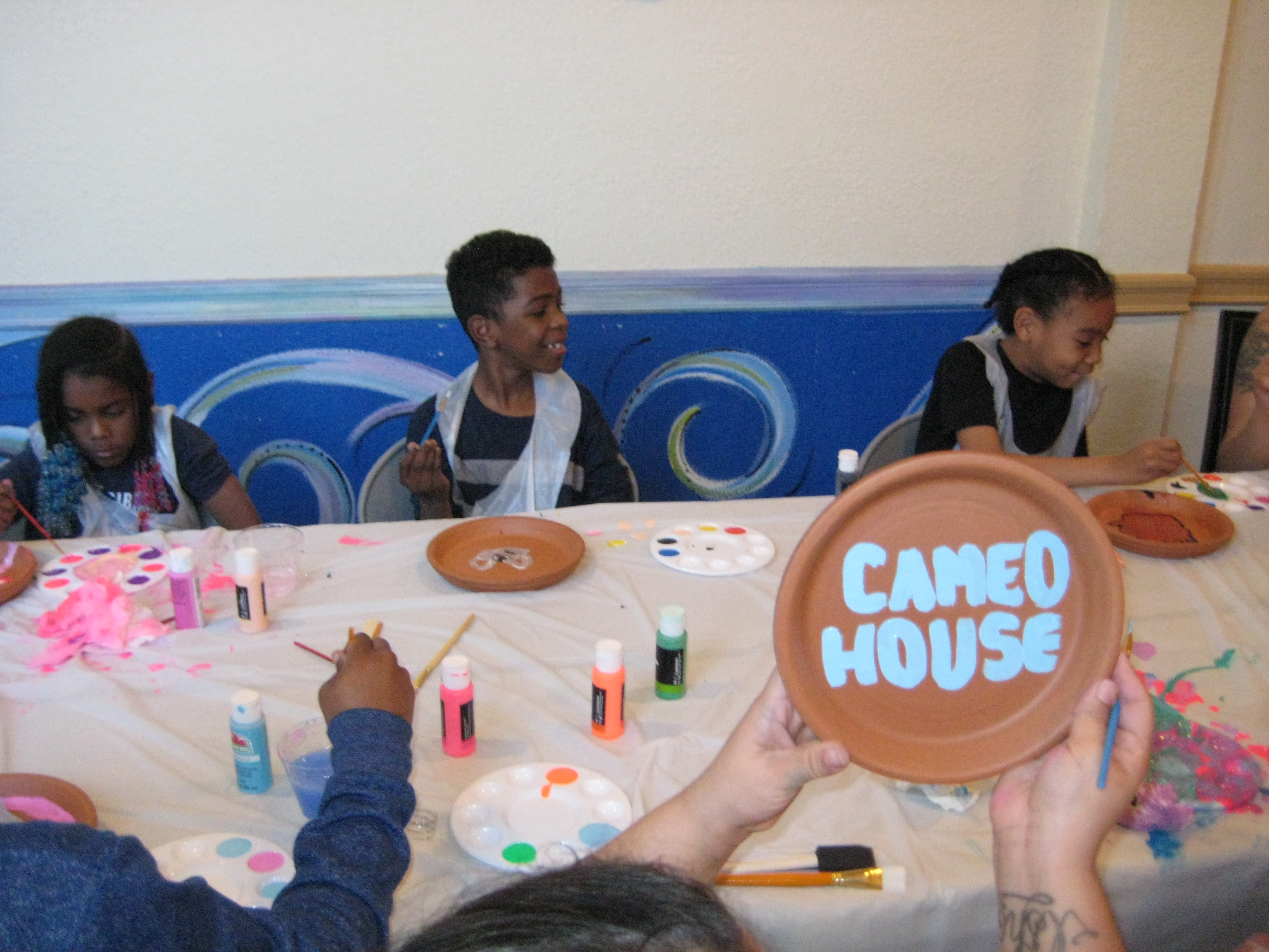 Cameo House families enjoy painting ceramic pots together as part of a beautification project.